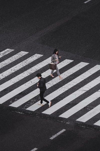 白天在人行道上行走的男女航拍